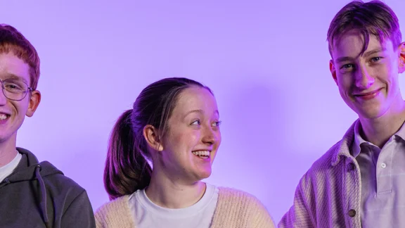 Drei Jugendliche lachen in die Kamera