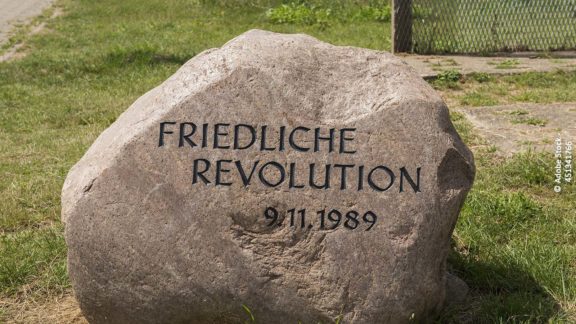 Stein mit Aufschrift "Friedliche Revolution". Foto: Adobe Stock