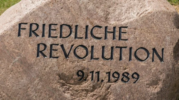 Stein mit der Aufschrift: "Friedliche Revolution, 9.11.1989"; Link zum Projekt "Friedliche Revolution 1989/1990".